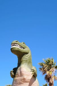 Low angle view of statue against clear blue sky