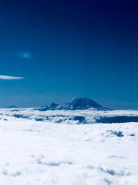 Scenic view of snowcapped mountains against blue sky