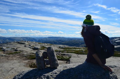 Rear view of woman standing on mountain against sky