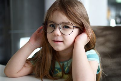 Portrait of little girl in glasses at home. 