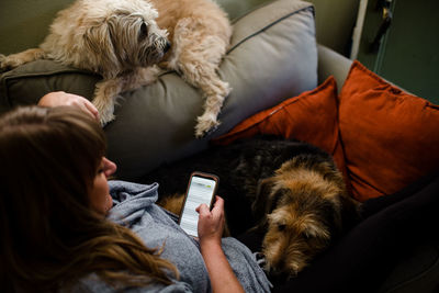 Mid 40's woman sitting on chair with her two large dogs