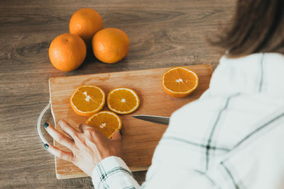 Midsection of woman holding fruits on table