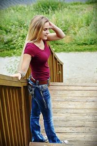 Full length of woman standing against railing