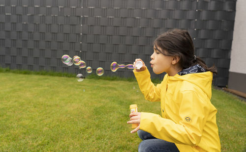 Full length of boy holding bubbles