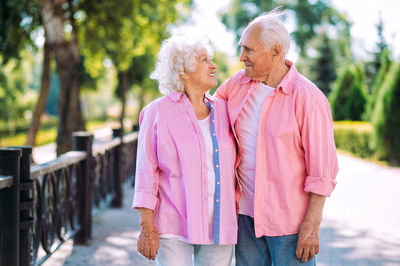 Rear view of couple standing against trees