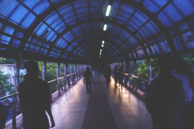 People walking in illuminated underground walkway