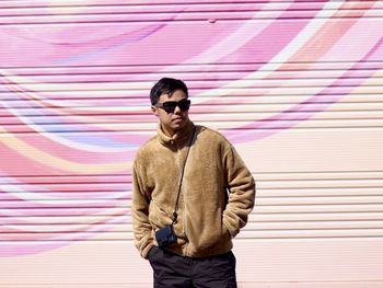 Young man standing against wall