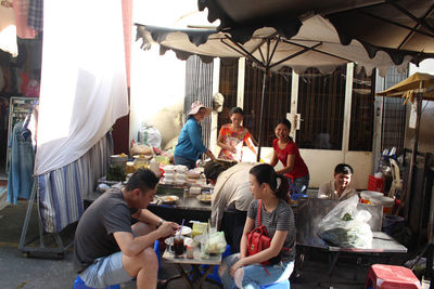 People sitting at market stall