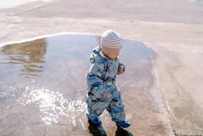 Rear view of boy standing at beach