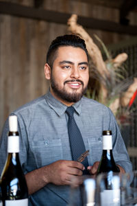 Bartender looking away while standing in bar