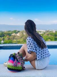 Full length of woman relaxing at poolside