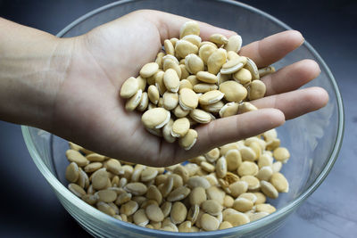 Cropped hand holding hyacinth beans