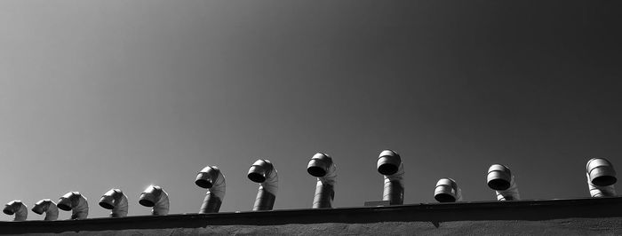 Low angle view of birds perching on cable