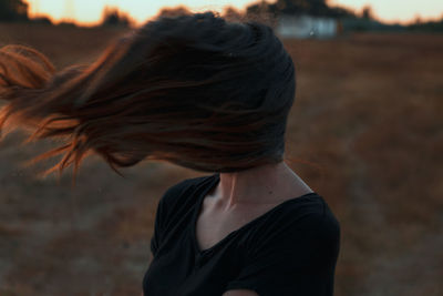 Rear view of woman standing against black background