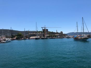 Sailboats in sea against clear blue sky
