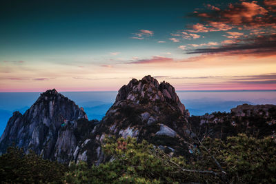 Rock formation on sea against sky during sunset