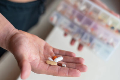 Cropped hand of woman holding pills