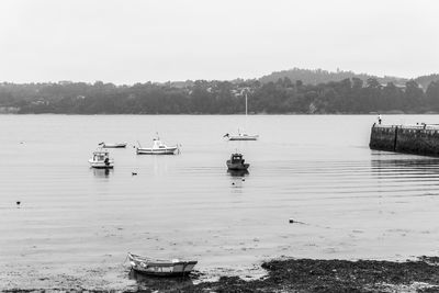 Sailboats moored in lake against sky