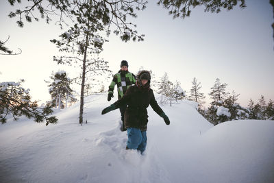 Two friends walking together in winter scenery