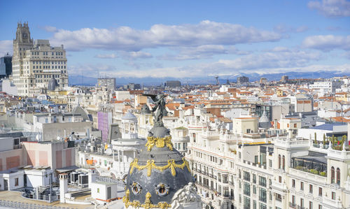 Statue of cityscape against cloudy sky