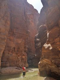 Full length of man in river amidst rock formations