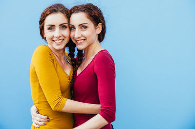 Portrait of smiling siblings against blue background