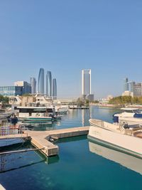 View of boats in harbor against clear sky