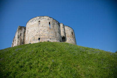 Low angle view of fort against clear blue sky