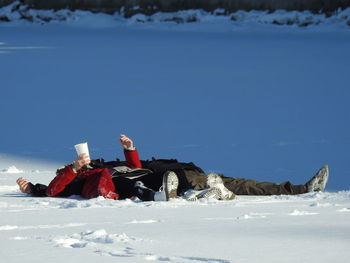 People lying on snow covered land