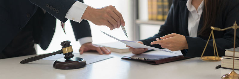 Midsection of lawyer working at table