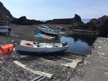 Sailboats moored on sea against clear sky