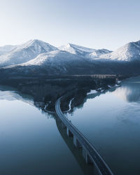 Scenic view of silvenstein reservoir in winter. the sun shines on the snowcapped mountains.
