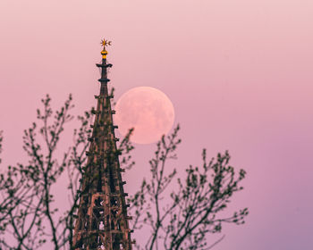 Low angle view of communications tower against sky during sunset