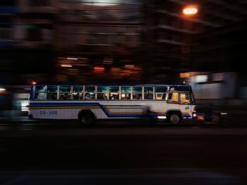 Cars on illuminated bus at night