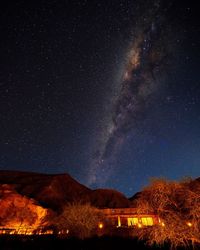 Scenic view of illuminated mountain against milky way sky 