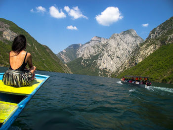People in boat on mountain against sky