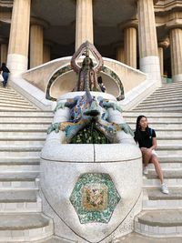 Full length of woman standing against staircase