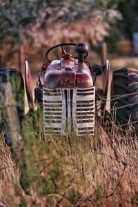 Close-up of abandoned tractor on field