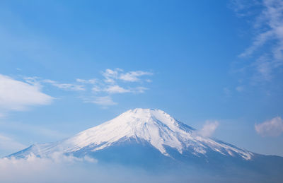 Scenic view of snowcapped mountains against blue sky