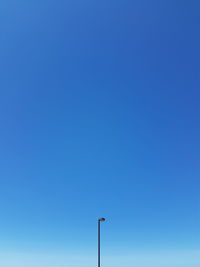 Low angle view of street light against blue sky