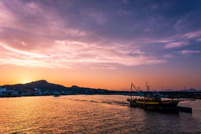 Sailboats in sea against sky during sunset