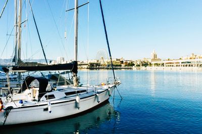 Sailboats moored sea against clear sky