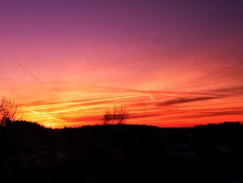 Silhouette trees against romantic sky at sunset