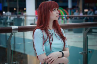 Young woman standing by railing