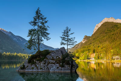 Scenic view of lake and mountains against blue sky