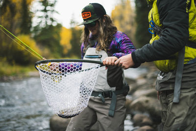 Man and woman holding fishing at roaring fork river