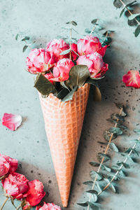 High angle view of pink roses in ice cream cone on table