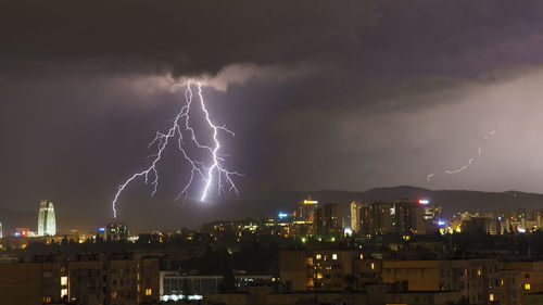 Low angle view of illuminated city against sky at night