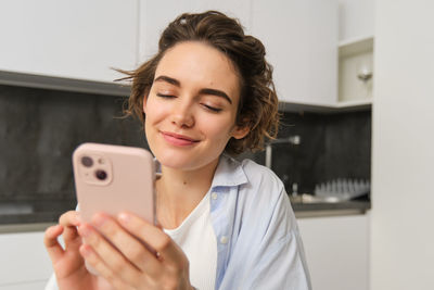 Young woman using mobile phone at home