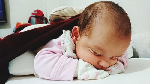 Close-up of cute baby sleeping on bed at home